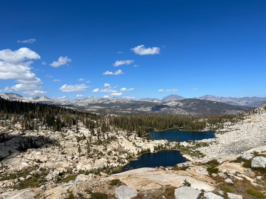 Breathtaking view of rocky landscapes and lakes under a vibrant blue sky in Yosemite National Park.